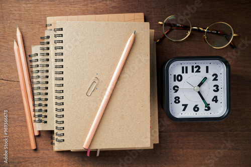 Wallpaper Mural Pile of brown notebooks with a clock on the wood table, finish writing, creative work and time Torontodigital.ca