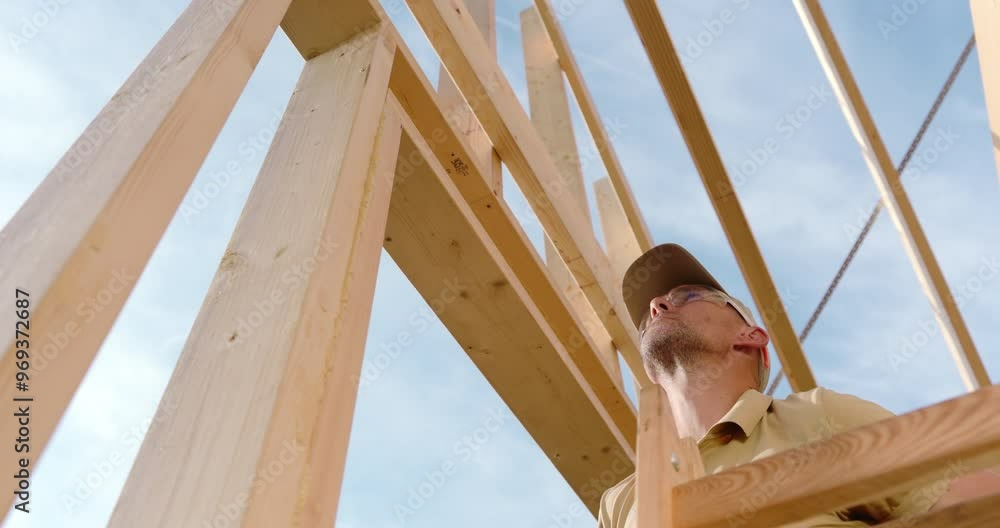 Construction Worker Assembling Wooden Framework on a Sunny Day Outdoors Construction Worker Assembling Wooden Framework on a Sunny Day Outdoors