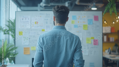 A digital marketing strategist mapping out future trends on a whiteboard in a tech-savvy office