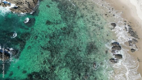 ocean with sand and rocks at the beach of Whangarei Heads in the North Island, New Zealand photo