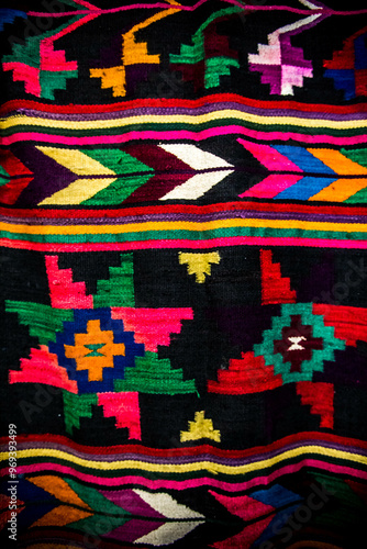 Obraz na płótnie Ornament of traditional Ukrainian multicolored colorful rug. Hutsul ethnic woven smooth hand-woven wool rug with geometric ornaments background and texture. Detail of authentic local motif carpet. w salonie