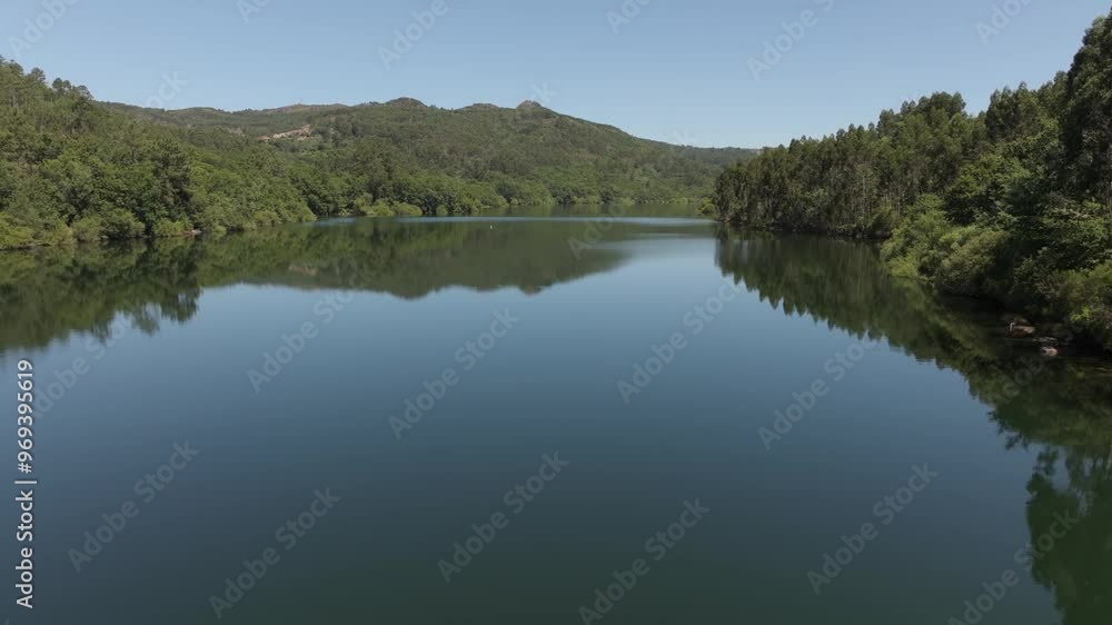 Drone peaceful view of forest lake with blue sky near Encoro de Eiras in Pontevedra, Galicia, Spain Drone peaceful view of forest lake with blue sky near Encoro de Eiras in Pontevedra, Galicia, Spain