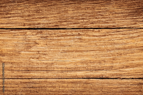 Close-up shot of weathered wooden surface with horizontal grain and cracks.