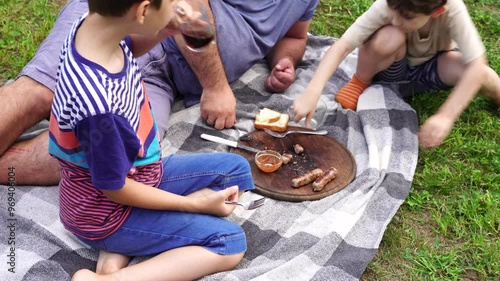 Father and sons have picnic on the backyard, have fun and time together photo