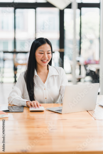 A woman working on laptop, smiling in bright office space Free Download A woman working on laptop, smiling in bright office space - GFXLoad