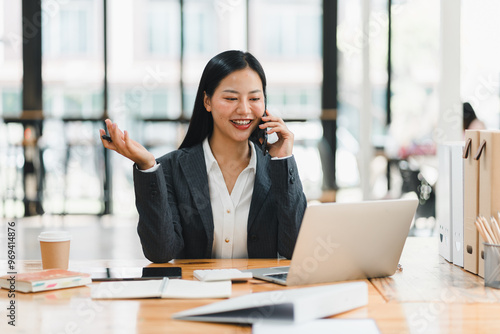 Efficient businesswoman on call, smiling while working on laptop