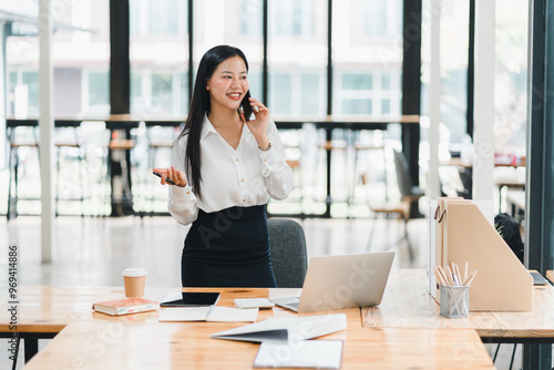 Efficient businesswoman talking on phone in modern office