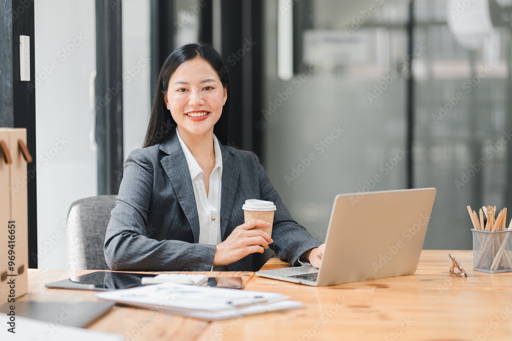 Professional woman smiling with coffee at modern office desk Professional woman smiling with coffee at modern office desk