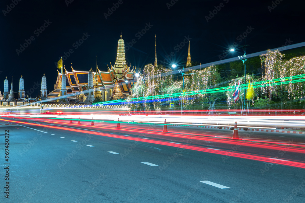 Obraz premium Long exposure light trails in front of the Grand Palace and Wat Phra Kaeo at night , Bangkok, Thailand