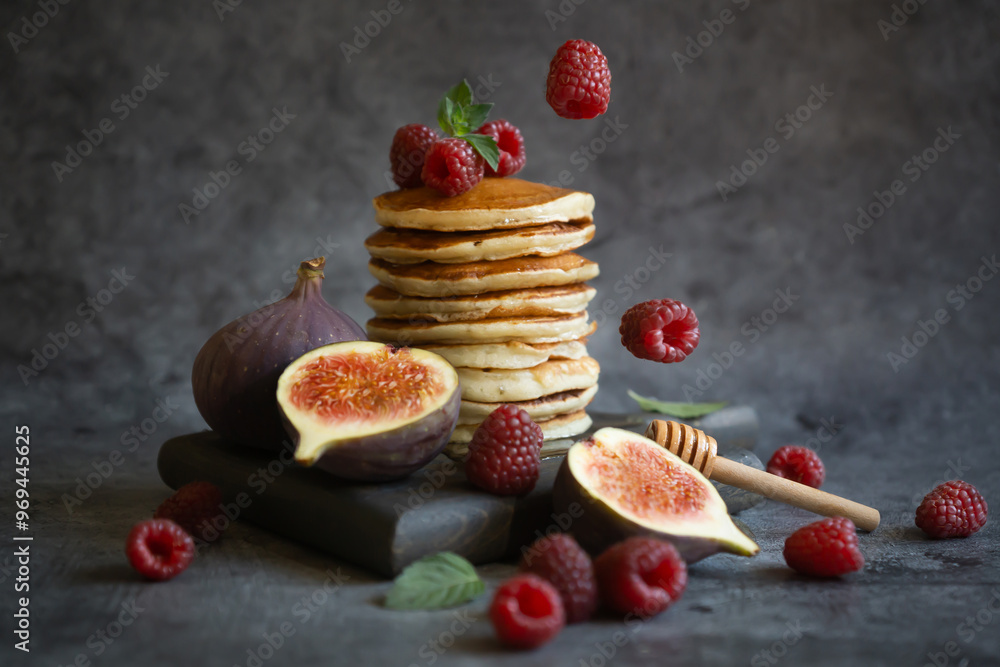 Pancakes with raspberries and figs on a dark background. Pancakes with raspberries and figs on a dark background.