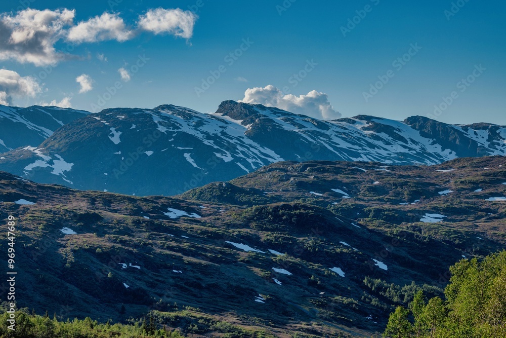 Fototapeta premium Snow-capped mountains under a clear blue sky.