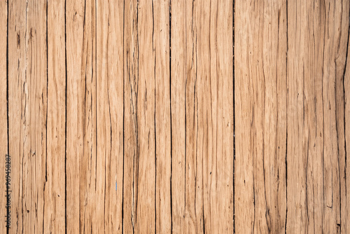 Close up of weathered brown wood with natural cracks and grain pattern.