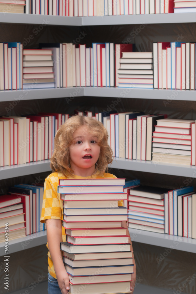 Amazed school kid hold stack of books. Nerd pupil. Back to school. School kid pupil studying in school library. Child reading book in library on bookshelf background. Amazed school kid hold stack of books. Nerd pupil. Back to school. School kid pupil studying in school library. Child reading book in library on bookshelf background.