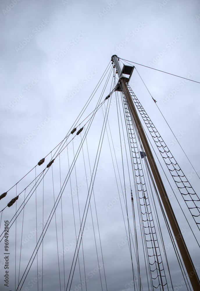 Obraz premium looking up at ship sails at dusk on cloudy night (sailor sailing boat sailboat) mast down sail platform top view night nightfall rope ladder clipper sooner maritime marine travel navy clouds