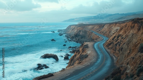 A scenic coastal road hugging the edge of a cliff, with waves crashing against the rocks below.