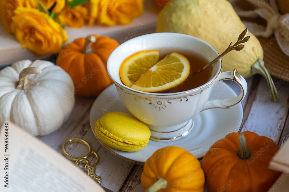 Cup of tea with orange and small pumpkins on white table, September. Cup of tea with orange and small pumpkins on white table, September.