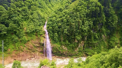 A view a waterfall in a lush.