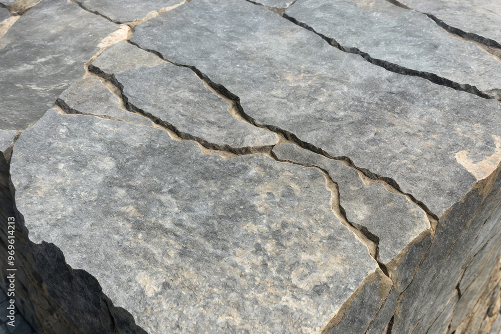 Obraz premium stone wall texture with cracks running through it, baking in the summer sun