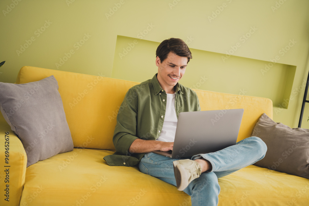 Photo of young attractive man wearing stylish clothes sitting cozy divan modern interior home house indoors Photo of young attractive man wearing stylish clothes sitting cozy divan modern interior home house indoors