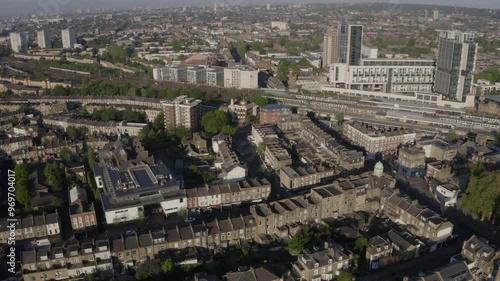 Wide aerial approaching sunlit North London urban neighbourhood Finsbury Park with trains arriving in station  photo