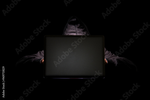 A person in a dark room using a laptop, internet phishing, hacking, data security threats, data breach, cyber security concept