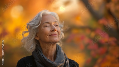 Peaceful mature woman enjoying autumn sunlight in nature 