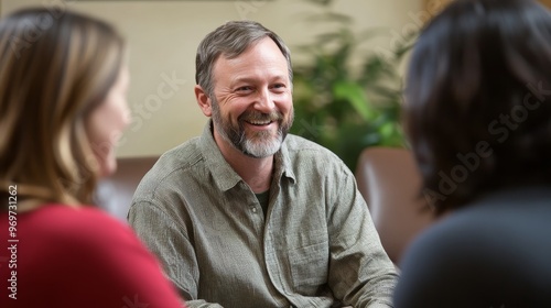 Three adults engage in a lively discussion, sharing smiles in a cozy indoor environment filled with plants, creating a warm and inviting atmosphere