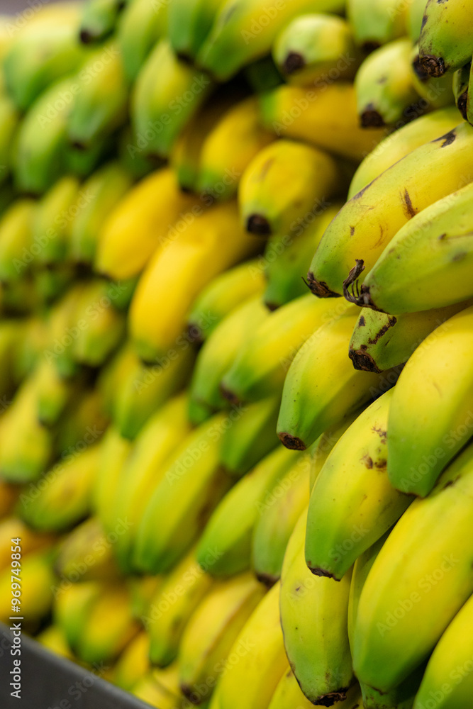Close-up vertical view of a bunch of ripe bananas stacked together in a market stall Close-up vertical view of a bunch of ripe bananas stacked together in a market stall