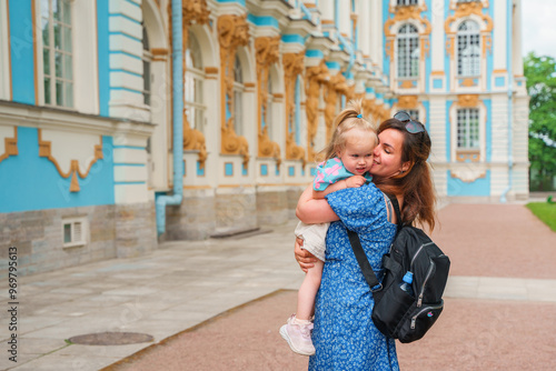 Little girl child with ner young mother walks to Catherine's Park with a palace, family tourism, active childhood.