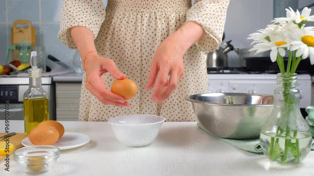 Woman separates yolk and white over bowl on kitchen preparing food at home, close-up view. Cooking protein dish, pastry, baking with eggs. Cuisine, cook meal on kitchen. Fresh organic ingredients. Woman separates yolk and white over bowl on kitchen preparing food at home, close-up view. Cooking protein dish, pastry, baking with eggs. Cuisine, cook meal on kitchen. Fresh organic ingredients.