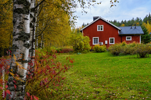 Wooden red house in the Finnish countryside forest in autumn