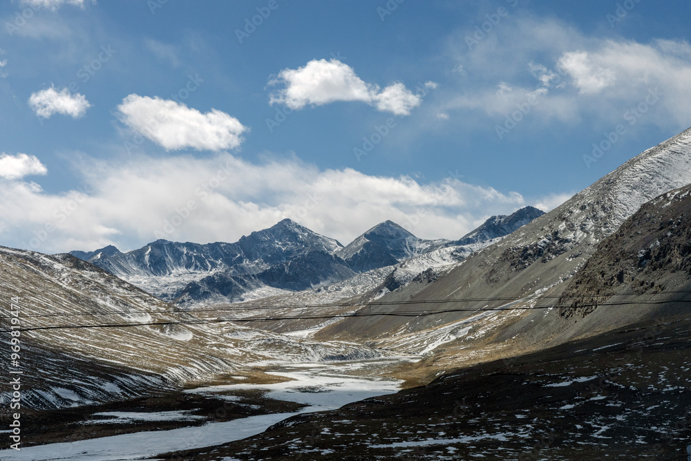 Obraz premium Mountain landscape, Beautiful view of rocks, the picturesque mountain gorge, tops against the blue sky filled with white clouds.