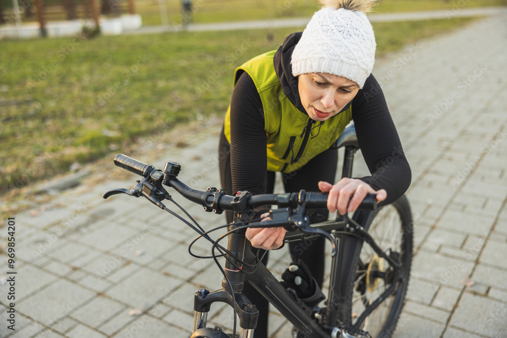 Woman Inspects Her Mountain Bike in a Park Woman Inspects Her Mountain Bike in a Park