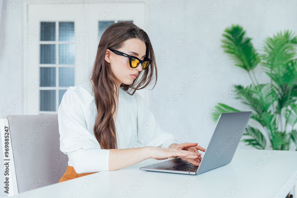 Business woman working on laptop online in office and smiling