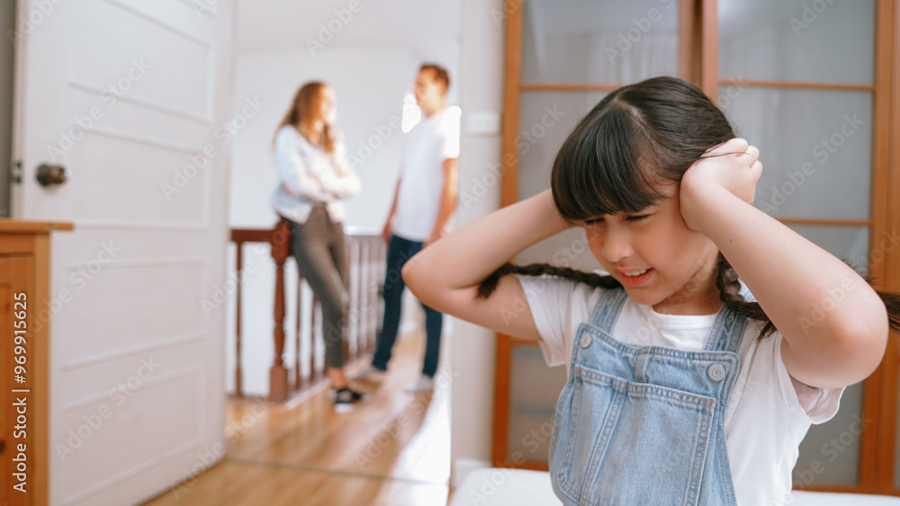 Stressed and unhappy young girl huddle in corner, cover her ears blocking sound of her parent arguing in background. Domestic violence at home and traumatic childhood develop to depression. Synchronos Stressed and unhappy young girl huddle in corner, cover her ears blocking sound of her parent arguing in background. Domestic violence at home and traumatic childhood develop to depression. Synchronos