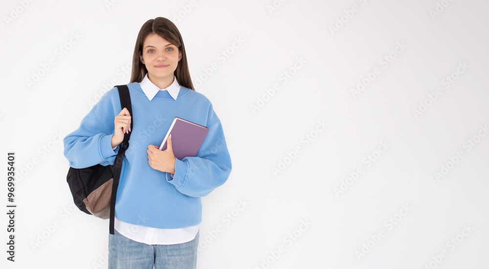 Caucasian girl student in blue sweatshirt with folder, books, notebook, notepad in hands smiling isolated on white studio background, copy space Caucasian girl student in blue sweatshirt with folder, books, notebook, notepad in hands smiling isolated on white studio background, copy space