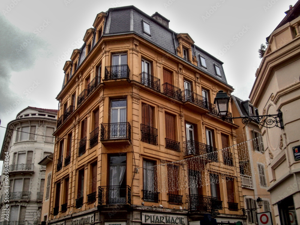 Aix-les-Bains, France - December 11th 2012 : old yellow building in the city, maybe in art deco style. Aix-les-Bains, France - December 11th 2012 : old yellow building in the city, maybe in art deco style.