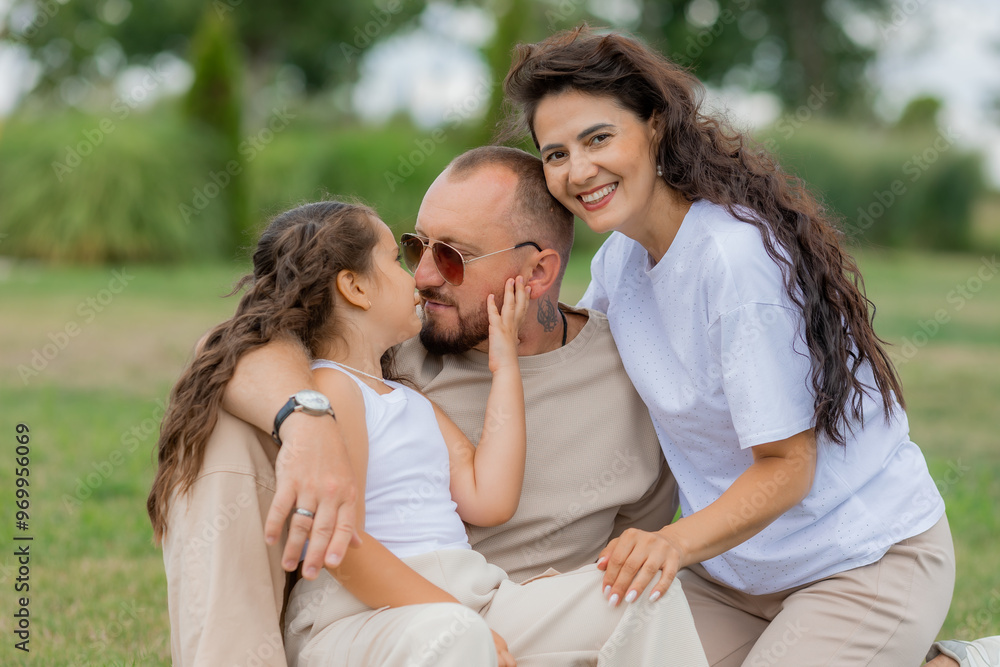happy family is relaxing on a green lawn in the park in summer happy family is relaxing on a green lawn in the park in summer