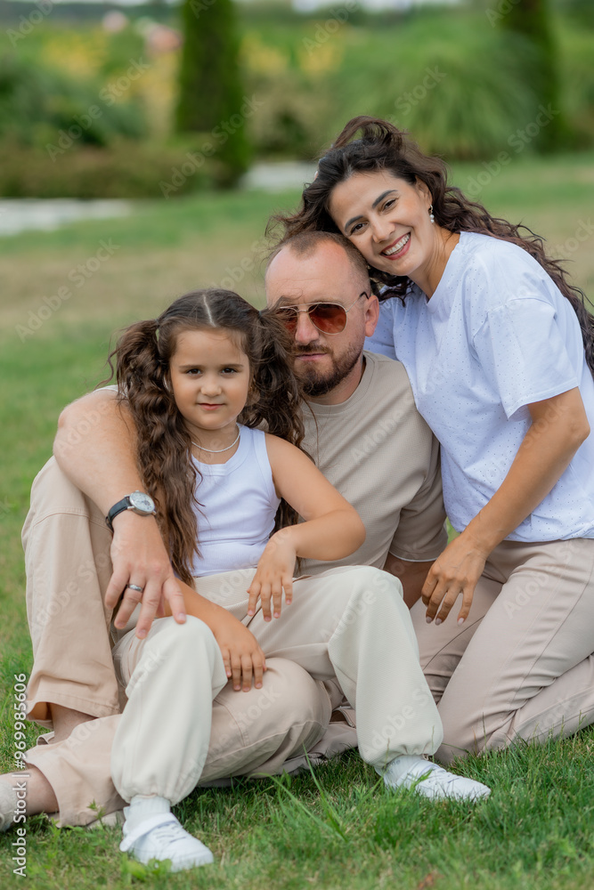 happy family is relaxing on a green lawn in the park in summer happy family is relaxing on a green lawn in the park in summer