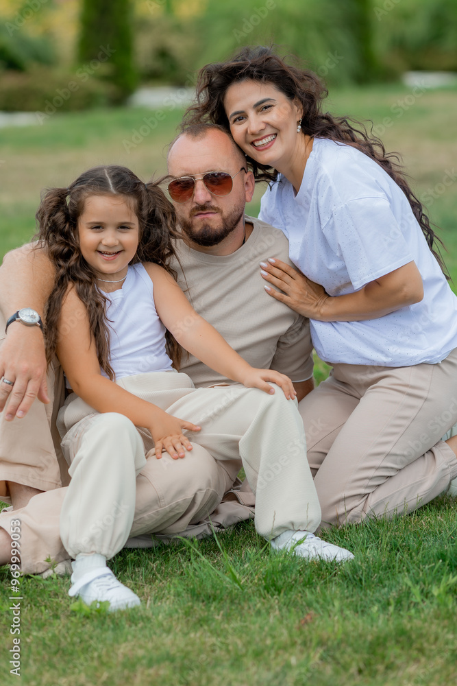 happy family is relaxing on a green lawn in the park in summer happy family is relaxing on a green lawn in the park in summer