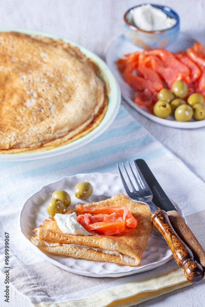 Pancakes with gravlax, cottage cheese and olives. A traditional dish for Maslenitsa or Carnival.