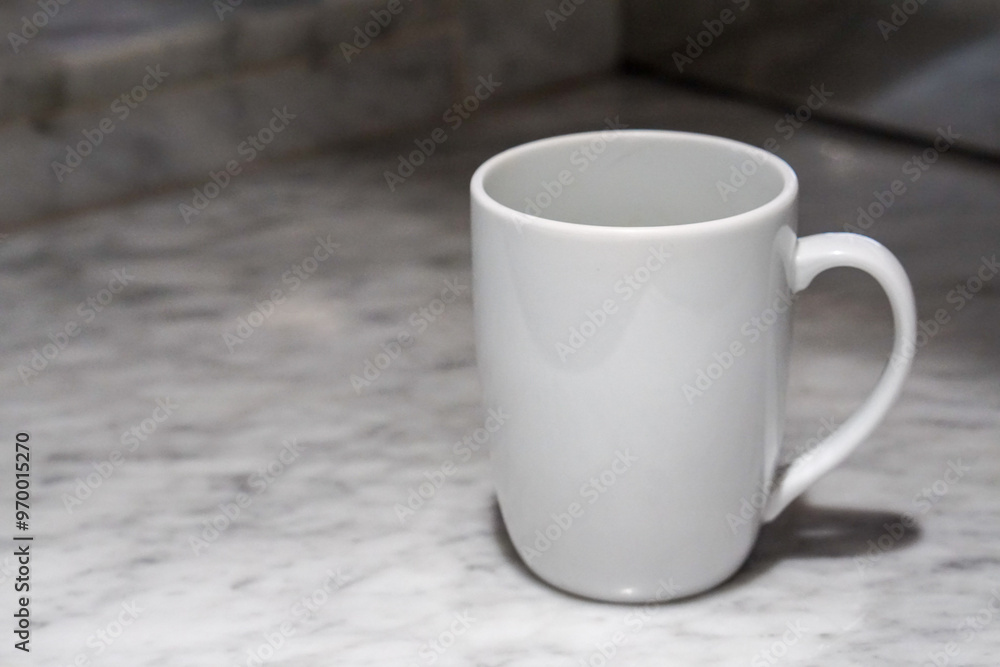 Obraz premium A white coffee cup sits on a marble table.