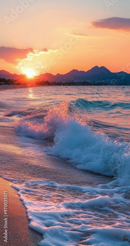 Golden sunset over calm waves at a beach with distant hills in the background