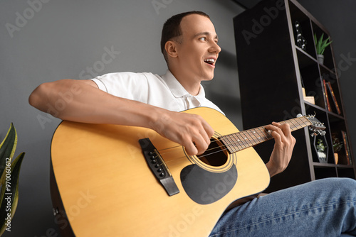 Young man playing guitar at...