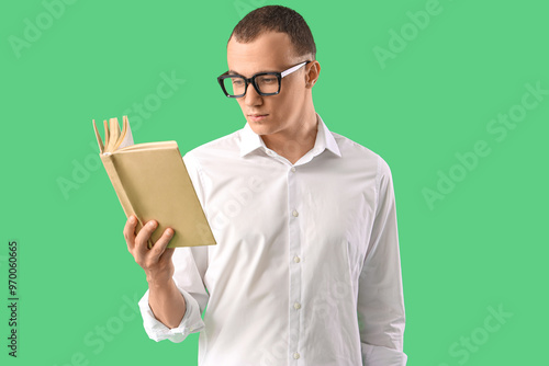 Young man reading book on g...