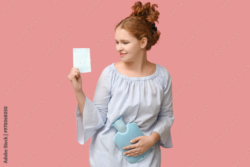 Beautiful young woman with hot water bottle and menstrual pad on pink background Beautiful young woman with hot water bottle and menstrual pad on pink background