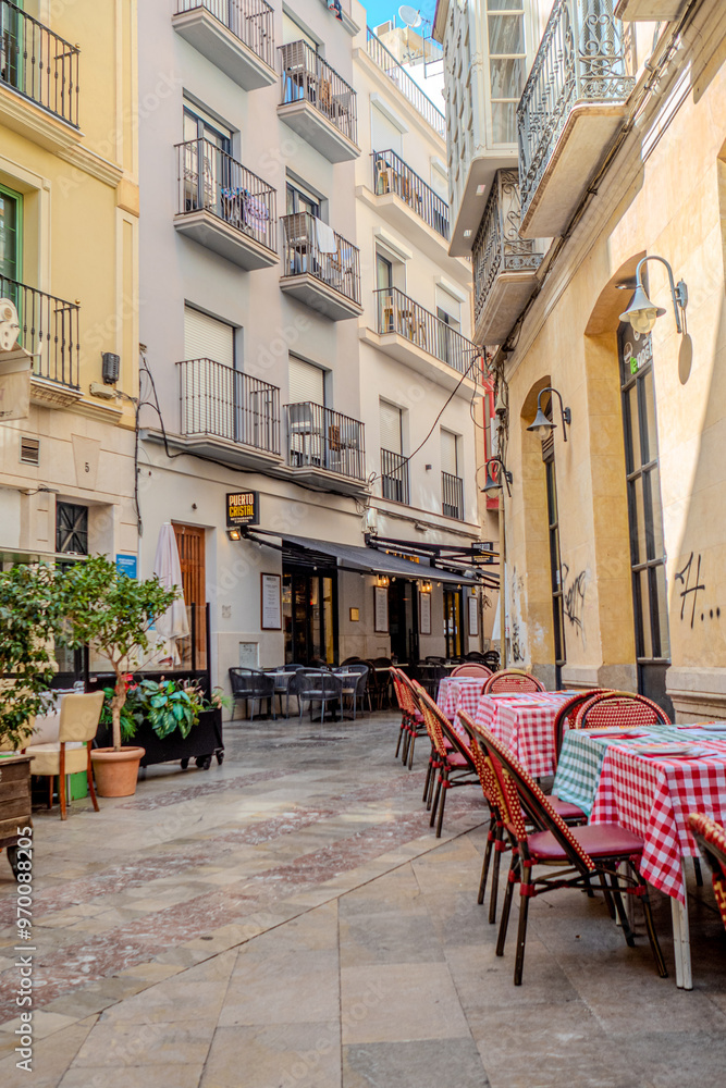 Fototapeta premium malaga old town architecture details during day hour, empty restaurant tables with no people
