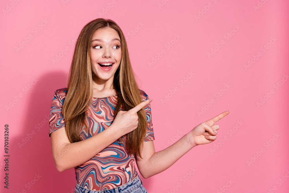 Portrait of impressed teen with long hair dressed colorful shirt look indicating at promo empty space isolated on pink color background Portrait of impressed teen with long hair dressed colorful shirt look indicating at promo empty space isolated on pink color background