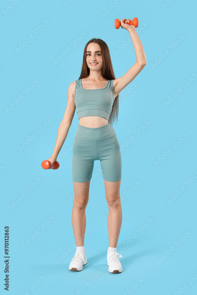Young sporty woman with dumbbells on blue background Young sporty woman with dumbbells on blue background