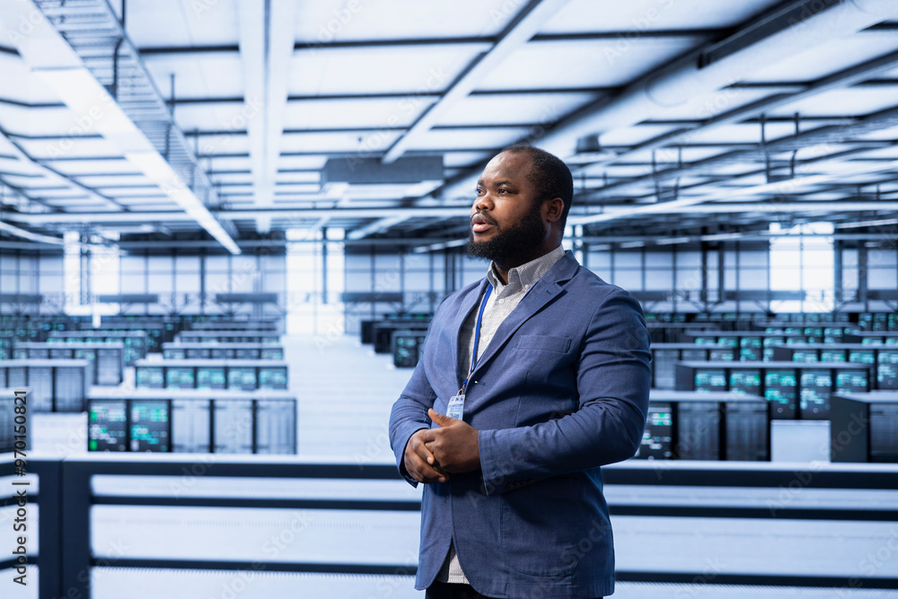 Engineer in data center identifying and solving technical errors related to data center equipment. African american man managing, maintaining and securing server hub workspace Engineer in data center identifying and solving technical errors related to data center equipment. African american man managing, maintaining and securing server hub workspace